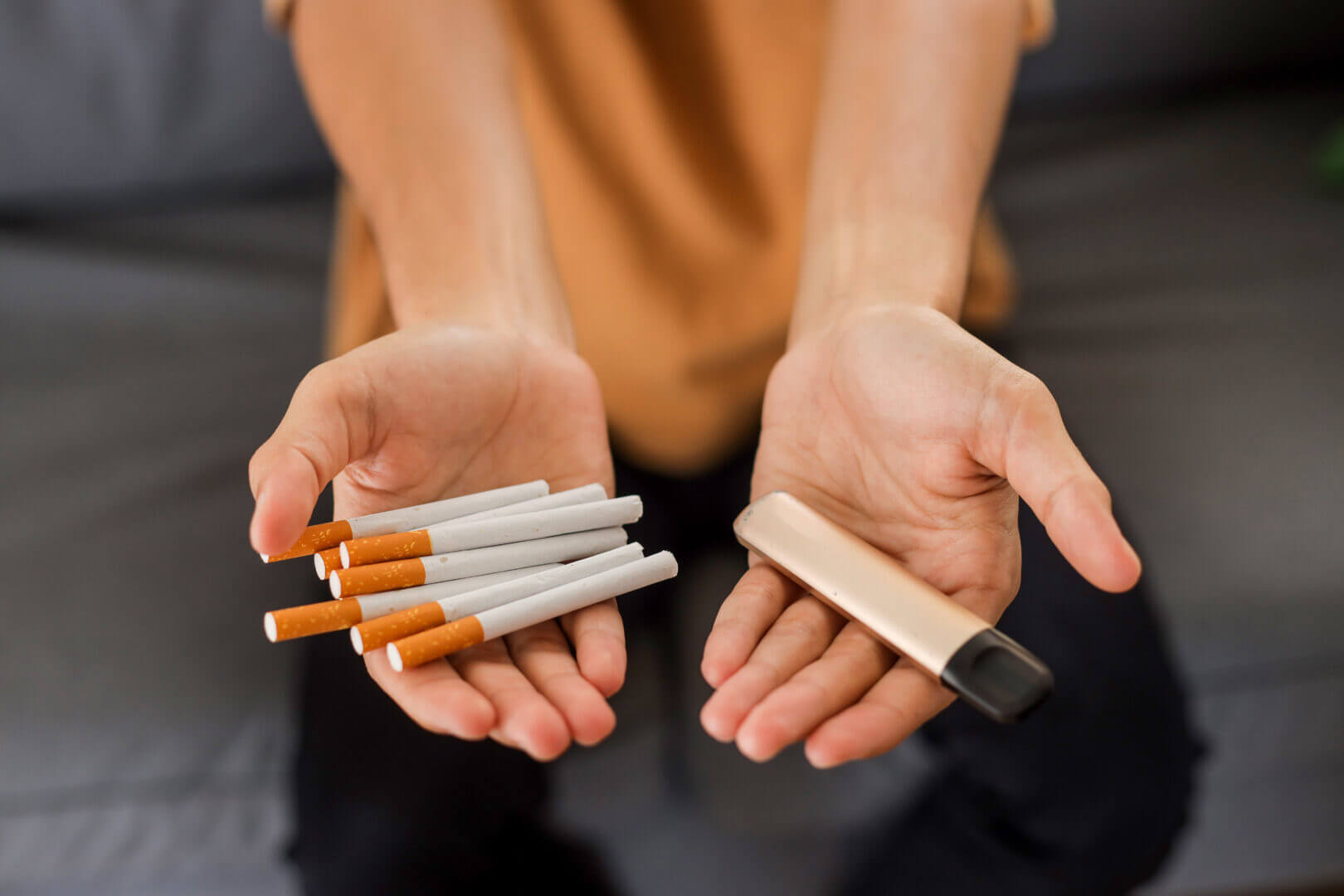 Cigarette vs e cigarette concept. Man holding cigarette and vape.