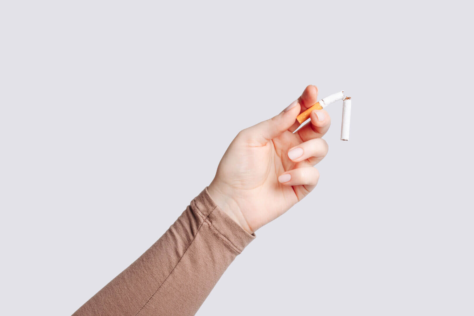 Woman holding broken cigarette in hand. Woman refusing cigarettes