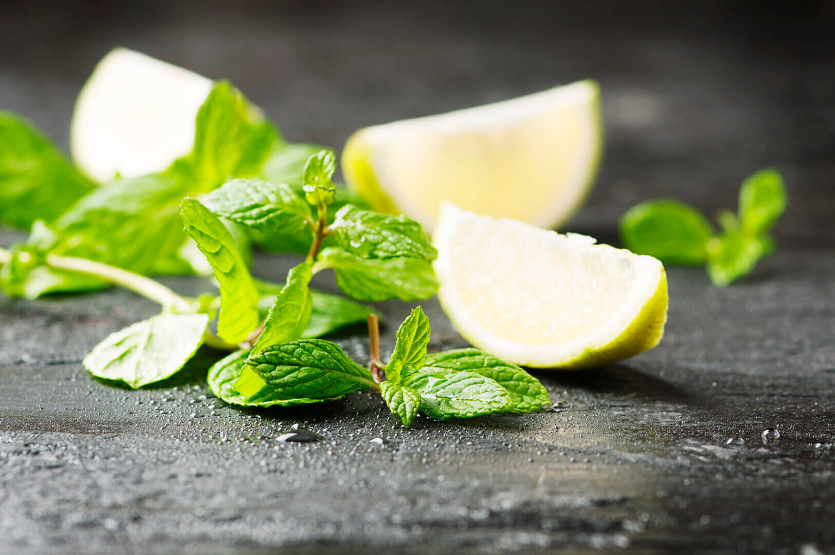 Fresh lemon anf green mint on the black table